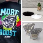 imagem do pó TPU para DTF branco e do pó TPU para DTF preto, dois pacotes de Pó para DTF e arte criada com pó TPU para DTF aplicada em camiseta.